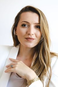 Confident businesswoman in a white blazer poses for a portrait in Dubai, showcasing a professional look ideal for brand representation.